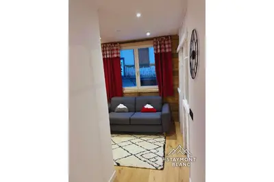 a living room with a couch and a window at Charmant 2 pièces cosy au cœur de Saint-Gervais in Saint-Gervais-les-Bains