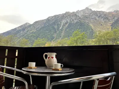 a table with two cups and a vase on it at CHAMONIX CENTRE le Grepon in Chamonix-Mont-Blanc