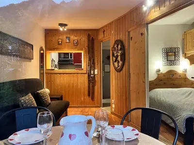 a room with a table and chairs and a bedroom at CHAMONIX CENTRE le Grepon in Chamonix-Mont-Blanc