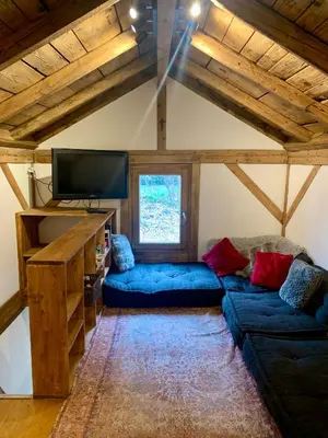 a living room with a blue couch and a tv at Gorgeous Mini-Chalet Chamonix in Chamonix-Mont-Blanc