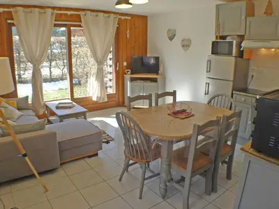 a kitchen and living room with a table and chairs at Appartement T3 cosy avec terrasse et parking, animaux admis, au pied de la navette ski-bus - FR-1-629-96 in Samoëns