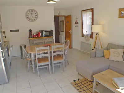 a living room with a table and a couch at Appartement T3 cosy avec terrasse et parking, animaux admis, au pied de la navette ski-bus - FR-1-629-96 in Samoëns