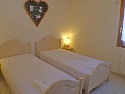 two beds in a room with a heart on the wall at Appartement T3 cosy avec terrasse et parking, animaux admis, au pied de la navette ski-bus - FR-1-629-96 in Samoëns