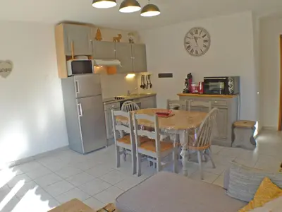 a kitchen with a table and a refrigerator at Appartement T3 cosy avec terrasse et parking, animaux admis, au pied de la navette ski-bus - FR-1-629-96 in Samoëns