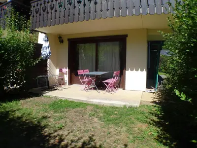a patio with two chairs and a table in front of a house at Appartement T3 cosy avec terrasse et parking, animaux admis, au pied de la navette ski-bus - FR-1-629-96 in Samoëns