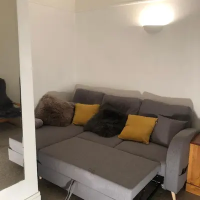 a gray couch with pillows on it in a living room at Little Mont Blanc - Saint Gervais in Saint-Gervais-les-Bains