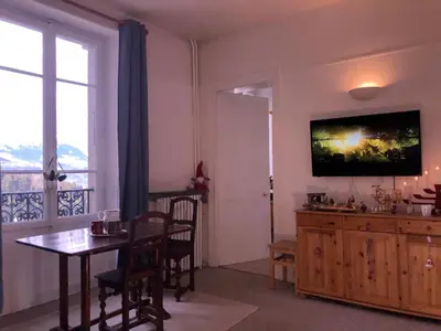 a dining room with a table and a television on the wall at Little Mont Blanc - Saint Gervais in Saint-Gervais-les-Bains