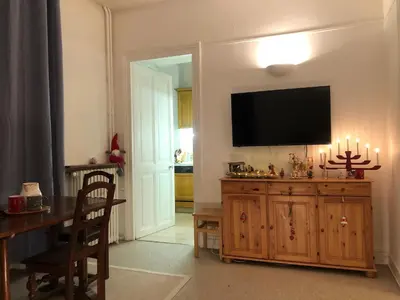 a living room with a television and a wooden entertainment center at Little Mont Blanc - Saint Gervais in Saint-Gervais-les-Bains