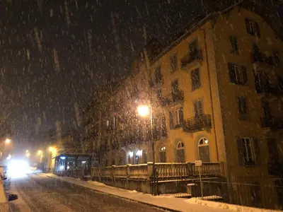 a snow covered street with a building and street lights at Little Mont Blanc - Saint Gervais in Saint-Gervais-les-Bains