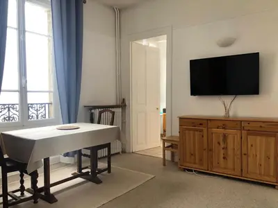a living room with a table and a flat screen tv at Little Mont Blanc - Saint Gervais in Saint-Gervais-les-Bains