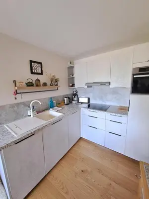 a kitchen with white cabinets and a sink at appartement Shangrila in Chamonix-Mont-Blanc