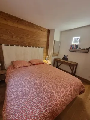a bedroom with a large bed with a wooden headboard at appartement Shangrila in Chamonix-Mont-Blanc