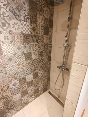 a shower in a bathroom with a tiled wall at appartement Shangrila in Chamonix-Mont-Blanc