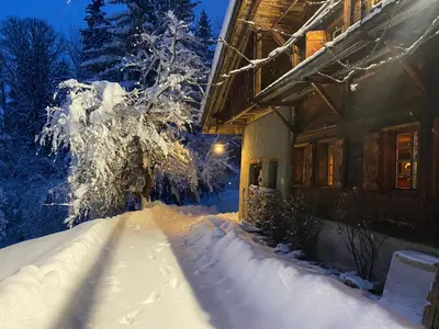 a snow covered yard next to a house at Arthaus Megève in Demi-Quartier
