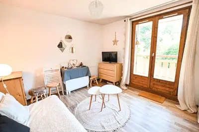 a living room with a couch and a table at Cocon du Front de Neige in Demi-Quartier