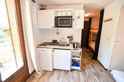 a small kitchen with a sink and a microwave at Cocon du Front de Neige in Demi-Quartier