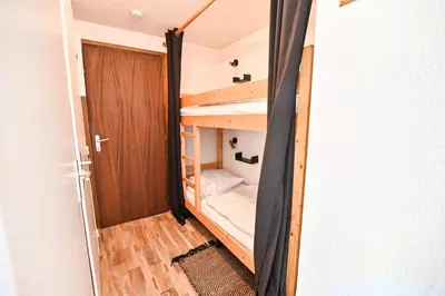 a small room with a bunk bed and a door at Cocon du Front de Neige in Demi-Quartier