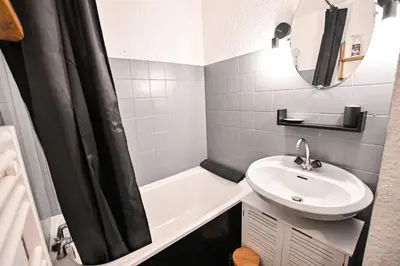 a bathroom with a sink and a toilet and a tub at Cocon du Front de Neige in Demi-Quartier