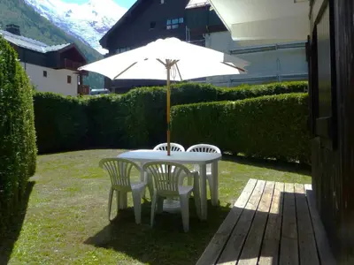 a white table with two chairs and an umbrella at Appartement calme avec garage privatif près du centre à Chamonix - FR-1-517-61 in Chamonix-Mont-Blanc