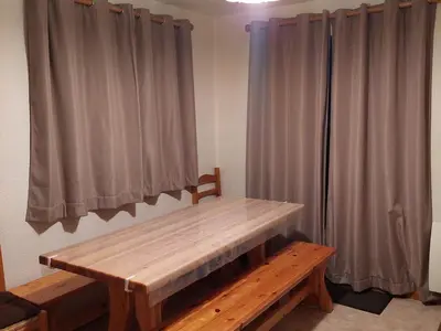 a wooden bench sitting in a room with curtains at Appartement calme avec garage privatif près du centre à Chamonix - FR-1-517-61 in Chamonix-Mont-Blanc