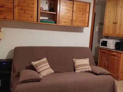 a brown couch with two pillows on it in a kitchen at Appartement calme avec garage privatif près du centre à Chamonix - FR-1-517-61 in Chamonix-Mont-Blanc