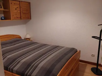 a bedroom with a bed with a striped blanket at Appartement calme avec garage privatif près du centre à Chamonix - FR-1-517-61 in Chamonix-Mont-Blanc