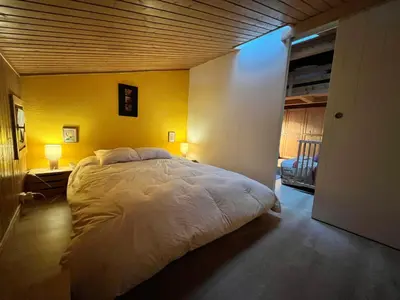 a bedroom with a large bed with a yellow wall at Appartement charmant avec balcon et casier à ski à Samoëns - FR-1-624-89 in Samoëns