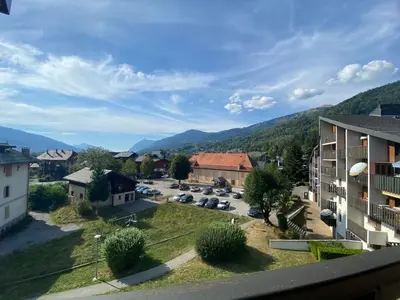 a view of a town with a building and a parking lot at Appartement charmant avec balcon et casier à ski à Samoëns - FR-1-624-89 in Samoëns
