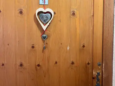 a wooden door with a heart on it at Appartement cosy proche centre et skibus, parking inclus - FR-1-624-90 in Samoëns