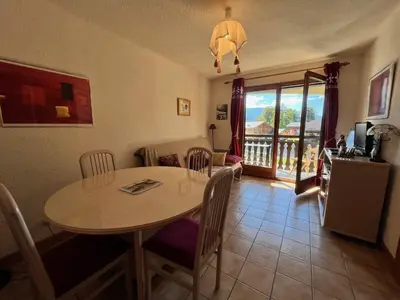 a dining room with a table and a balcony at Appartement cosy proche centre et skibus, parking inclus - FR-1-624-90 in Samoëns