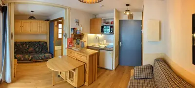a small kitchen with a desk and a refrigerator at Studio sympa a saint Gervais les bains in Saint-Gervais-les-Bains