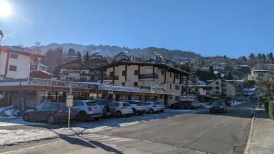 a city street with cars parked in front of buildings at Studio sympa a saint Gervais les bains in Saint-Gervais-les-Bains