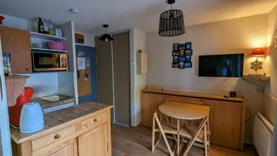 a kitchen with a desk and a table and a chair at Studio sympa a saint Gervais les bains in Saint-Gervais-les-Bains