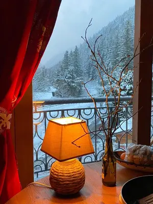 a lamp sitting on a table in front of a window at Happy Moose - Cosy Mont Blanc View apartment with sauna in Chamonix-Mont-Blanc