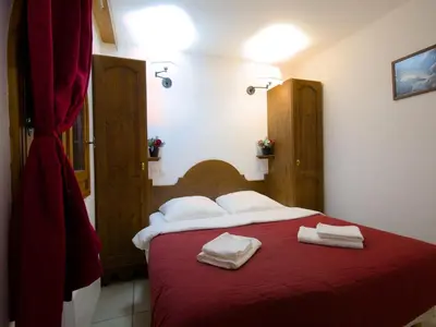a bedroom with a red bed with two towels on it at Happy Moose - Cosy Mont Blanc View apartment with sauna in Chamonix-Mont-Blanc