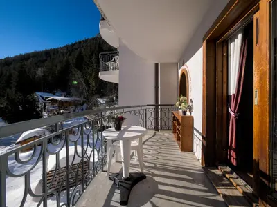 a balcony with a white table on the side of a building at Happy Moose - Cosy Mont Blanc View apartment with sauna in Chamonix-Mont-Blanc