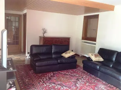 a green couch with a pillow on top of it at Les Grangettes 2 - DUPLEX - WIFI gratuite in Les Carroz d'Araches