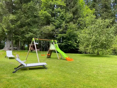 two swings and a swing set in a park at Les Grangettes 2 - DUPLEX - WIFI gratuite in Les Carroz d'Araches