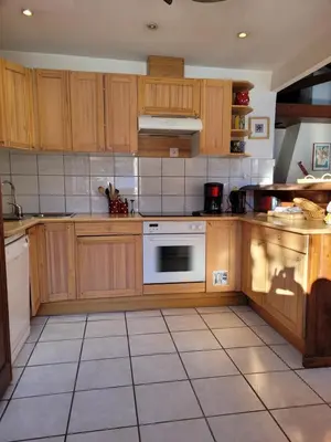 a kitchen with wooden cabinets and a white oven at Chalet LE TRIOLET in Chamonix-Mont-Blanc