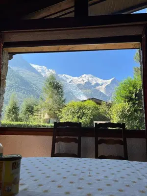a table with two chairs and a view of a mountain at Chalet LE TRIOLET in Chamonix-Mont-Blanc