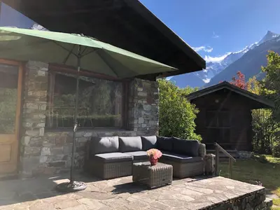 a couch sitting under an umbrella on a patio at Chalet LE TRIOLET in Chamonix-Mont-Blanc