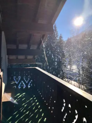 a balcony with a view of a snow covered tree at Chalet Rivière du Bon Nant Location de 6 à 14 personnes en Haute Savoie in Saint-Gervais-les-Bains
