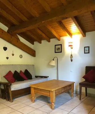 a living room with a bed and a coffee table at Chalet Rivière du Bon Nant Location de 6 à 14 personnes en Haute Savoie in Saint-Gervais-les-Bains