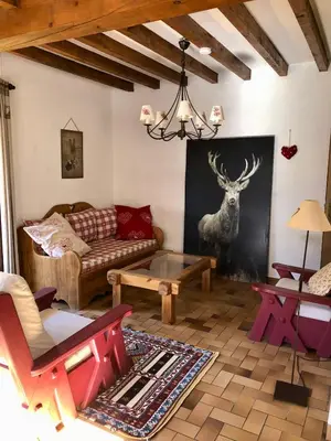 a living room with a couch and a deer on the wall at Chalet Rivière du Bon Nant Location de 6 à 14 personnes en Haute Savoie in Saint-Gervais-les-Bains