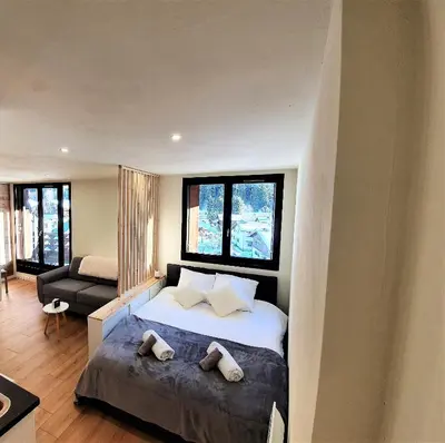 a bedroom with a large bed with two pillows at Grand Studio Aiguille du Midi et vue Mont Blanc in Chamonix-Mont-Blanc