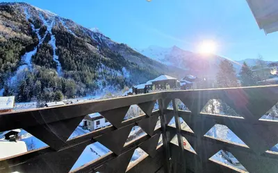 a bridge over a mountain with the sun in the background at Grand Studio Aiguille du Midi et vue Mont Blanc in Chamonix-Mont-Blanc