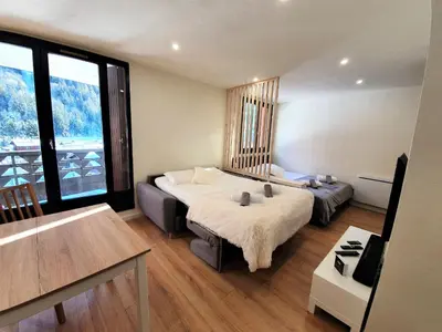 a hotel room with two beds and a large window at Grand Studio Aiguille du Midi et vue Mont Blanc in Chamonix-Mont-Blanc