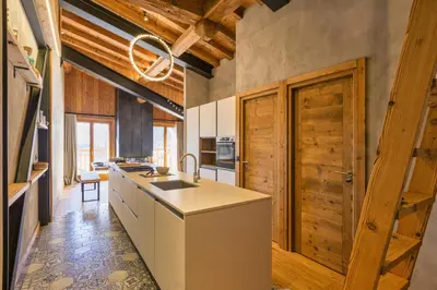 a kitchen with wooden ceilings and a wooden door at La Ferme à Roland ski in - ski out - Happy Rentals in Chamonix-Mont-Blanc