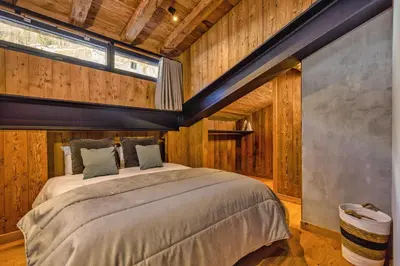 a bedroom with a large bed in a room with wooden walls at La Ferme à Roland ski in - ski out - Happy Rentals in Chamonix-Mont-Blanc