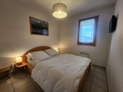 a bedroom with a bed and a window and a lamp at Appartement confort 4 pers avec balcon et garage, coeur de Samoëns - FR-1-629-101 in Samoëns